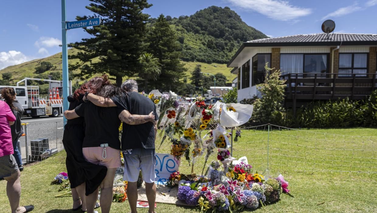 People lay flowers and hug at the cordon after a landslide at Mount Maunganui that tore through a holiday park last week.CHRISTEL YARDLEY / Waikato Times